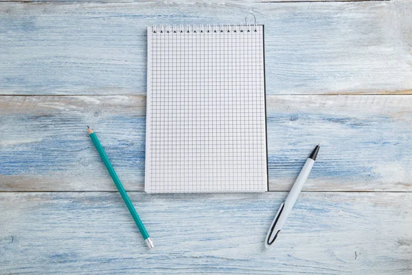 Notebook met pen of potlood op een blauwe en witte shabby Vintage w — Stockfoto