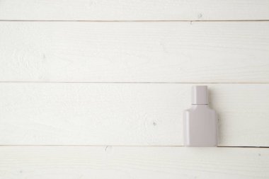 açık ahşap arka plan üzerinde parfüm gri şişe. düz yatıyordu