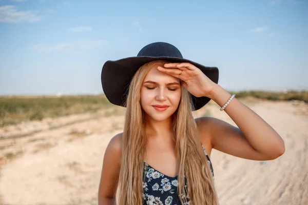 Um close-up retrato de uma menina loira de olhos azuis em um chapéu preto e — Fotografia de Stock