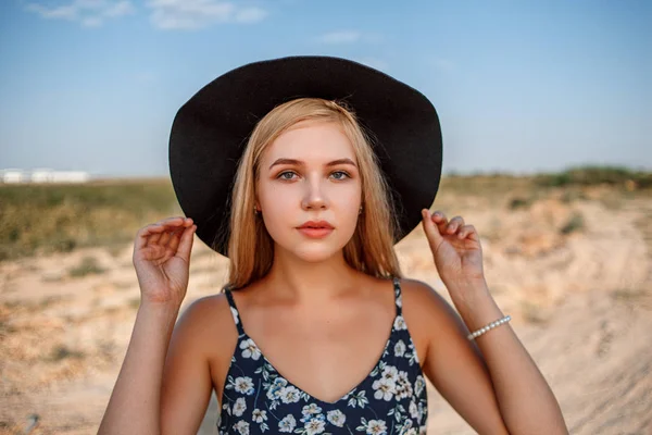 Ein Nahaufnahme-Porträt eines blauäugigen blonden Mädchens mit schwarzem Hut an — Stockfoto