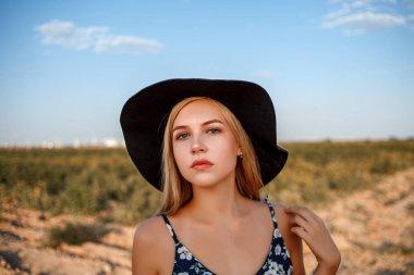 siyah şapkalı mavi gözlü sarışın bir kızın yakın çekim portresi