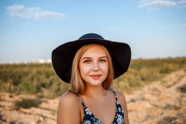 siyah şapkalı mavi gözlü sarışın bir kızın yakın çekim portresi