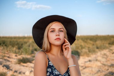 siyah şapkalı mavi gözlü sarışın bir kızın yakın çekim portresi