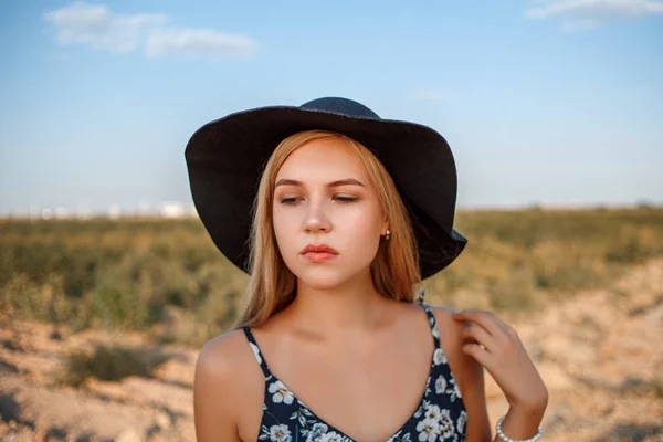 Um close-up retrato de uma menina loira de olhos azuis em um chapéu preto e — Fotografia de Stock