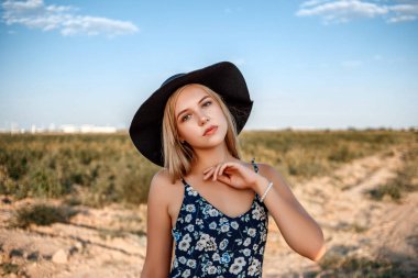 siyah şapkalı mavi gözlü sarışın bir kızın yakın çekim portresi