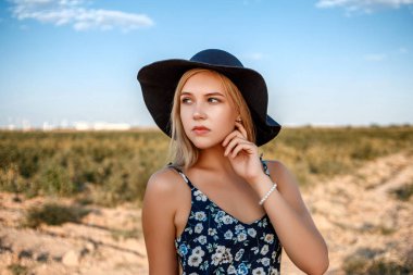 siyah şapkalı mavi gözlü sarışın bir kızın yakın çekim portresi