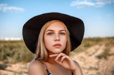 siyah şapkalı mavi gözlü sarışın bir kızın yakın çekim portresi