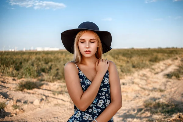 Egy közeli portréja egy kék szemű szőke lány egy fekete kalapot — Stock Fotó