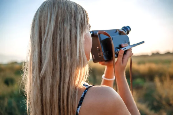 Portrét blondýny v květinové tiskové šatech se starožitnou videoklipkou — Stock fotografie