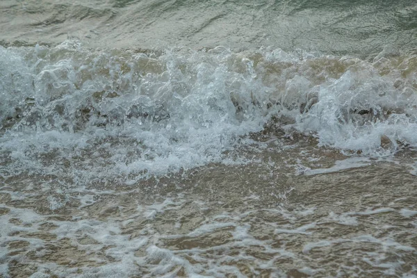 Fundo de ondas batendo em uma praia de areia em tempo tempestuoso — Fotografia de Stock