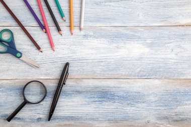 açık mavi eski ahşap arka plan üzerinde kırtasiye ve büyüteç. Hedef