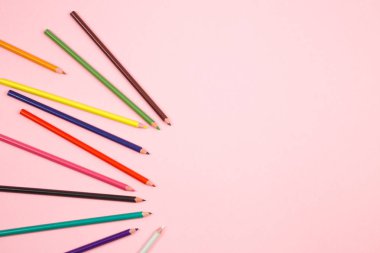 pembe izole arka plan üzerinde renkli kalemler. üst görünüm. düz yatıyordu.