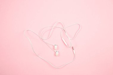 pembe izole arka plan üzerinde beyaz kablolu kulaklıklar. üst görünüm. Fl