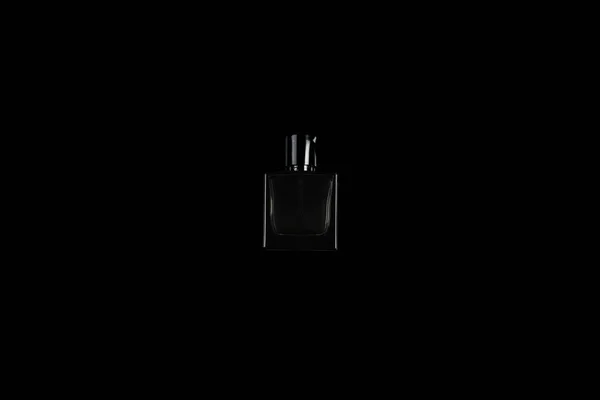 Malá tmavá láhev voňavky na černém izolovaném pozadí — Stock fotografie
