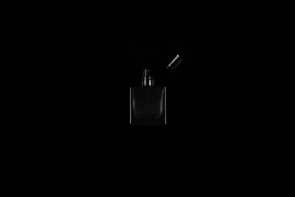 Small dark perfume bottle on black isolated background — Stock Photo, Image