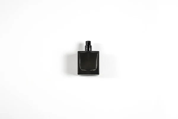 Pequeno frasco de perfume escuro no fundo isolado branco — Fotografia de Stock