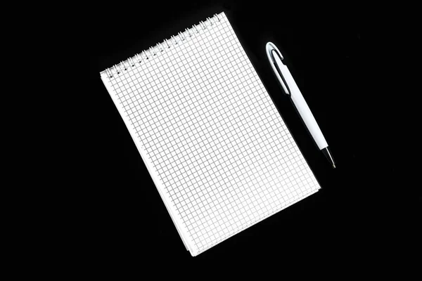 Paper notebook with ballpoint pen on black isolated background — Stock Photo, Image