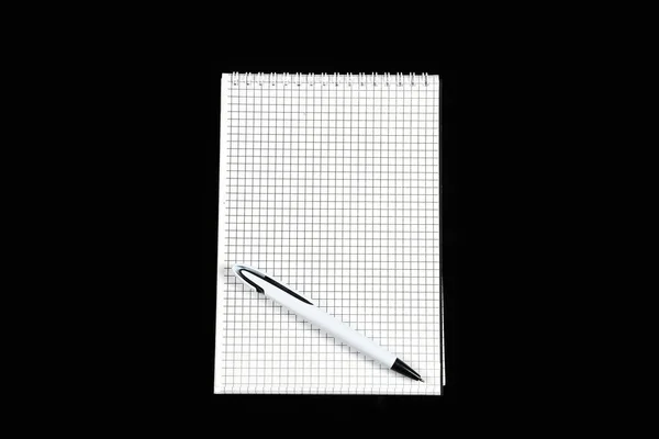 Cuaderno de papel con bolígrafo sobre fondo negro aislado — Foto de Stock