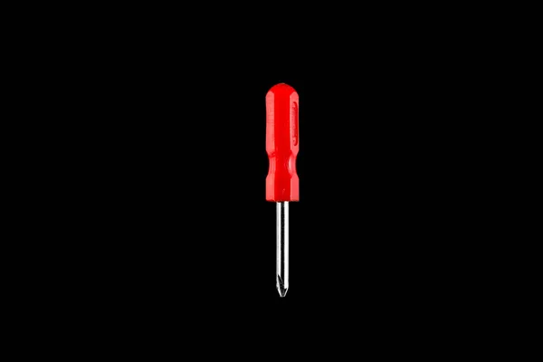 Small screwdriver with red handle on black isolated background — Stock Photo, Image