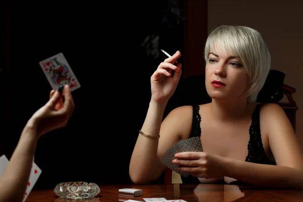 Une jeune blonde caucasienne en lingerie noire est assise à une table — Photo