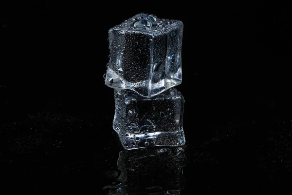 Кубики льда на черном изолированном стеклянном фоне — стоковое фото