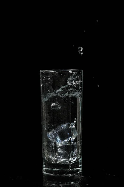 Verre d'eau transparent avec glaçons sur verre isolé noir b — Photo