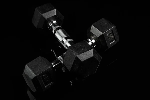 sports dumbbells with black rubber handle on black isolated back