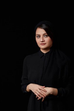 Siyah bluzlu, kahverengi saçlı, siyah deri etekli, siyah izole edilmiş genç ve güzel bir Müslüman kadın.