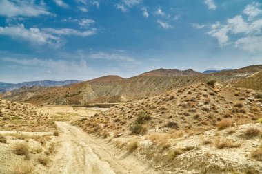Asya dağlarında kumlu bir yol. Kum yüzeyi yağmursuz kurumuş.