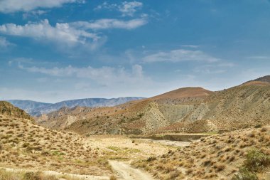 Asya dağlarında kumlu bir yol. Kum yüzeyi yağmursuz kurumuş.