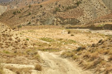 Asya dağlarında kumlu bir yol. Kum yüzeyi yağmursuz kurumuş.