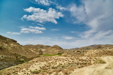 Asya dağlarında kumlu bir yol. Kum yüzeyi yağmursuz kurumuş.