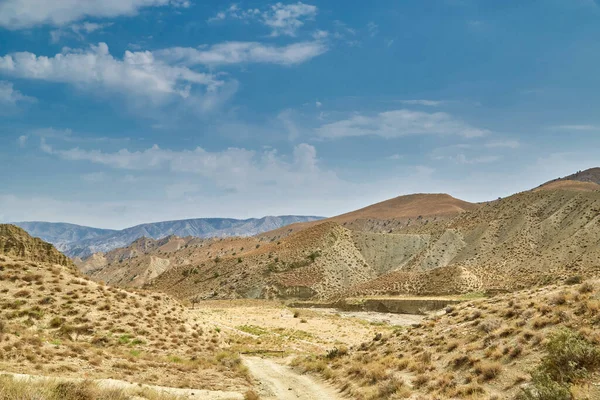Asya dağlarında kumlu bir yol. Kum yüzeyi yağmursuz kurumuş.