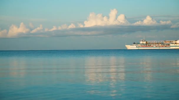 海に船が地平線に沿って泳ぐ 朝早く水に雲と船を反映します — ストック動画
