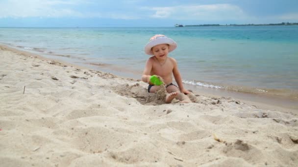 Kleiner Junge spielt am Strand im Sand am Meer — Stockvideo