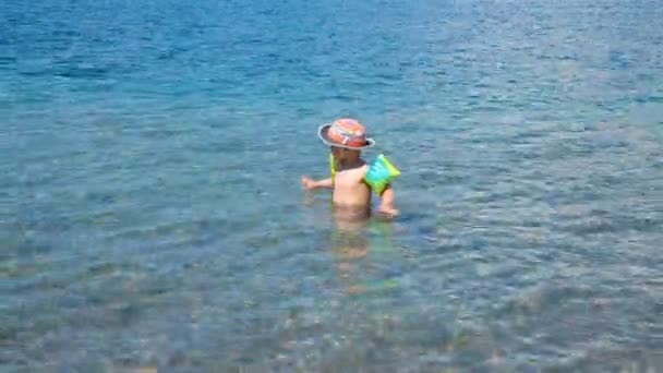 One small child learns to swim in the open sea, in the wild — Stock Video