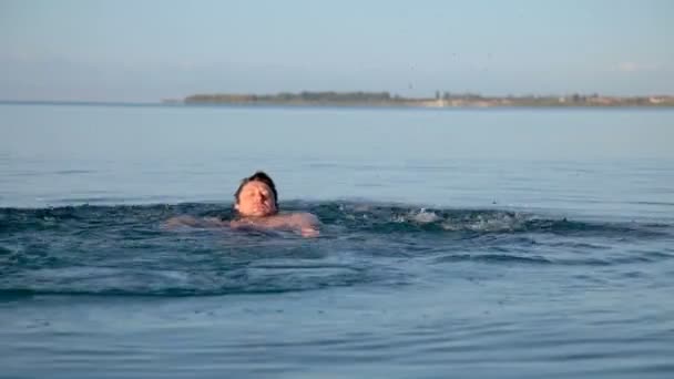 One man swims in the lake in the early morning — Stock Video