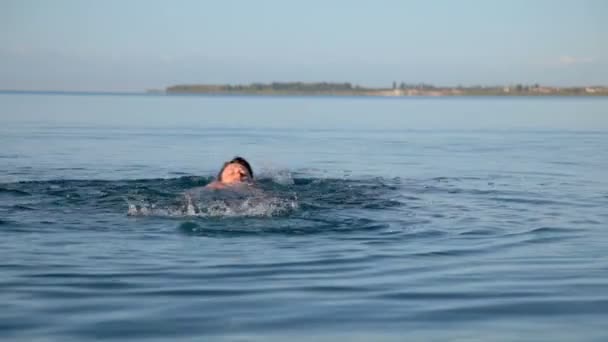 Bir adam sabahın erken saatlerinde gölde yüzüyor — Stok video