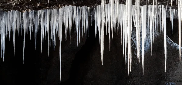 Many icicles hanging from the ceiling of the cave