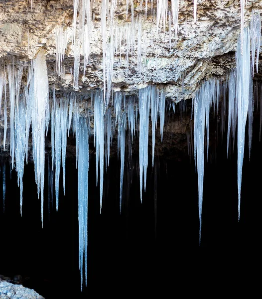 Many icicles hanging from the ceiling of the cave