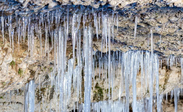 Many icicles hanging from the ceiling of the cave