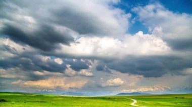 Baharda bir dağ vadisi üzerinde renkli bulutlar