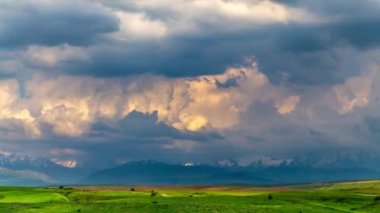 Baharda bir dağ vadisi üzerinde renkli bulutlar