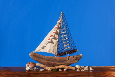 handmade wooden ship boat on a wooden and blue background.