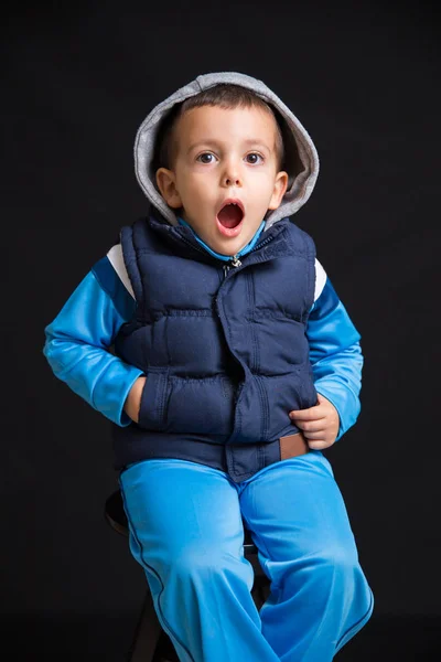 Portrait Surprised Little Boy Sitting Black Stool Isolated Black Background Stock Photo