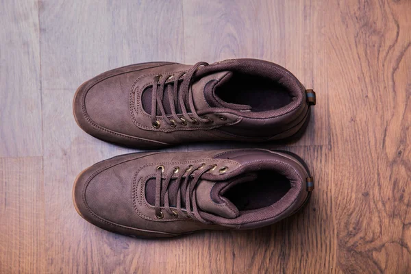 Pair of new trekking boots Isolated on wood background