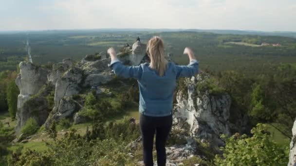 Kobieta stojąca na szczycie skały - szczęście — Wideo stockowe