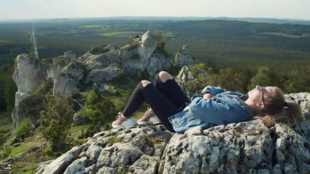 Женщина, лежащая на вершине горы — стоковое видео