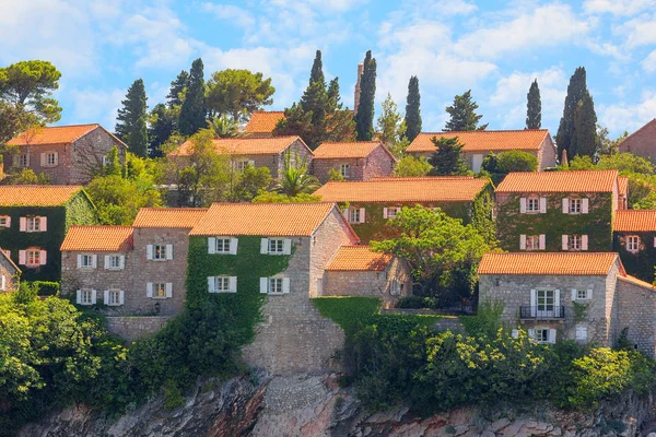 Budva'daki Sveti Stefan adasının bir parçası, gökyüzü ve bulutlarla yakın çekim. Karadağ.