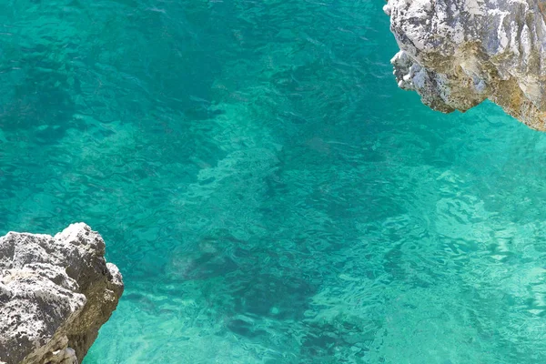 Açık turkuaz deniz suyu alt ve kaya köşelerini taşkın bir görünüm ile